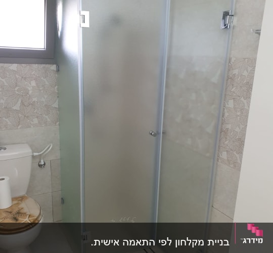 מקלחון זכוכית עם דלת פתוחה בחדר אמבטיה